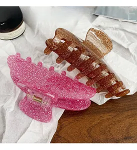 Detail of pink and amber glitter resin hair claw clips with shiny metallic springs