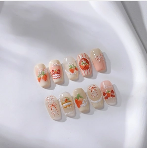 Macro shot of 3D embossed strawberry nail stickers with pearls and bow details