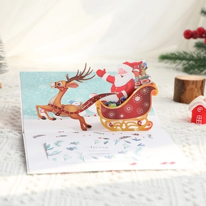 Biglietto di Natale 3D pop-up con Babbo Natale in una slitta con renne e decori festivi