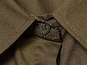 Macro detail of dark olive poplin shirt collar featuring twill cotton texture and resin button