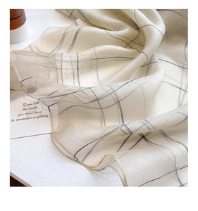 Close-up of lightweight beige silk wool scarf showing delicate plaid texture and drape