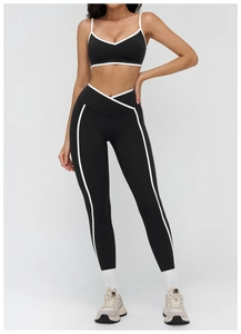 Detail showing the white contrast piping and V-shape waistband on black yoga set