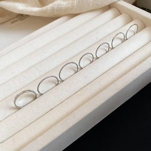 Detailed set of 7 minimalist silver rings in velvet display box showcasing varied textures