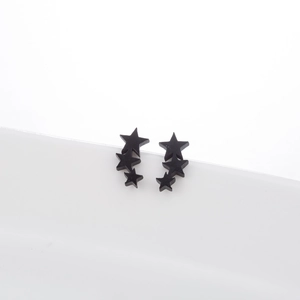 Minimalist black stainless steel triple star stud earrings on white background