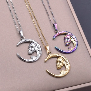 Detailed view of moon and skull pendant necklaces in silver, gold and rainbow finishes