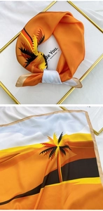 Detail of square silk scarf showing tropical palm tree silhouettes in orange and yellow