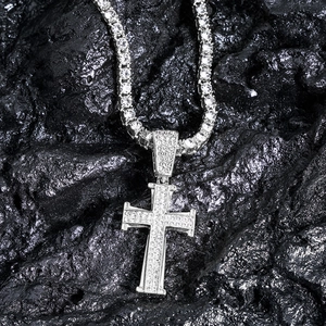 Close-up of hip hop cross pendant with small rhinestones on a silver tennis chain