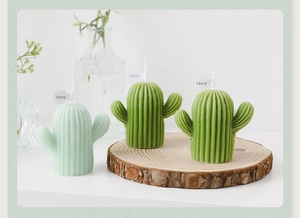 Détail de bougies en forme de cactus vert avec textures sur tranches de bois naturel