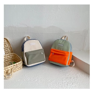 Close-up of stylish contrast color kids canvas backpacks with front zipper pocket