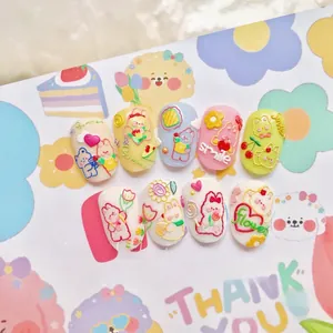 Macro view of 3D embossed press-on nails with pastel colors and cute resin cartoon motifs