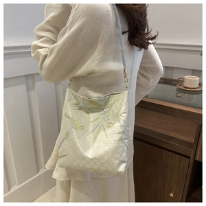 Detailed close-up of golden silk bamboo embroidery on a vintage style shoulder bag