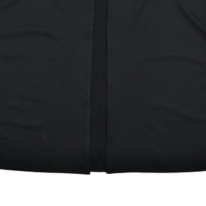 Detailed macro shot of fine stitching on the slit hem of a black bodycon dress