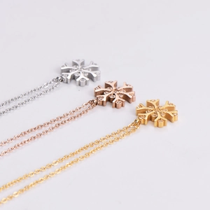 Three snowflake pendant necklaces in silver, rose gold, and yellow gold finish