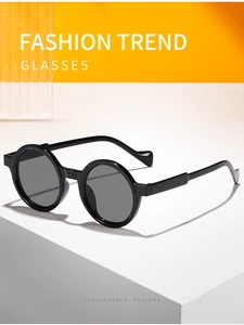 Detail of round black frame sunglasses on geometric blocks with yellow backdrop