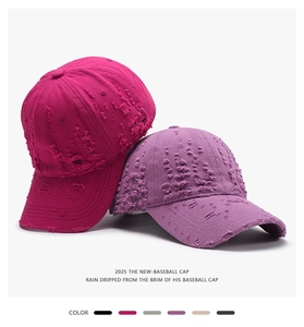 Detail view of distressed cotton baseball caps in rose red and purple colors