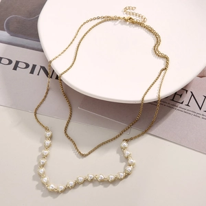 Detail of gold double-layer necklace with heart-shaped faux pearl charms and adjustable clasp