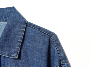 Détail du col d'une chemise en jean avec coutures contrastées et texture de tissu de qualité