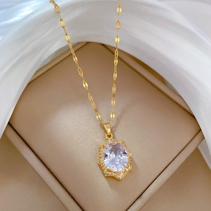 Detail of gold titanium necklace featuring a luxury oval zircon pendant on a jewelry box