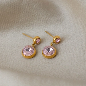 Détail de boucles d'oreilles dorées 18K avec doubles pierres de cristal rose sur soie