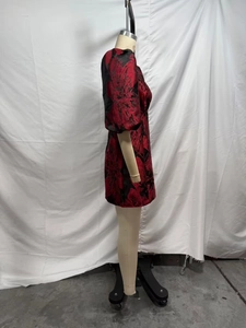 Gros plan sur le tissu jacquard floral rouge et noir de cette robe courte élégante