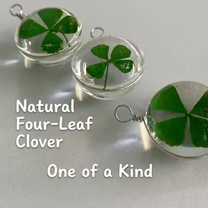 Handmade clear resin pendant featuring a natural four-leaf clover with silver metal ring