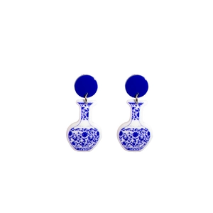 Detailed close-up of blue and white porcelain pattern earrings in a vase shape