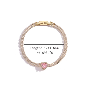 Macro view of gold-plated bracelet with pink heart gem and baguette cubic zirconia
