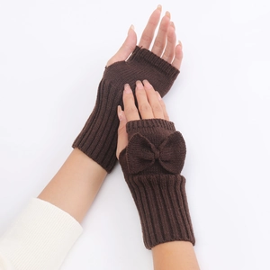 Close-up of dark brown knitted fingerless gloves with bow detail and textured knit pattern