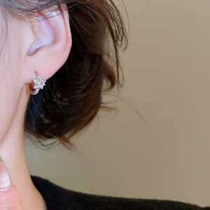Gros plan d'élégantes boucles d'oreilles étoile en argent avec zircons sur un mannequin