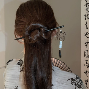 Detail of elegant butterfly hair stick with long tassel on a retro bun hairstyle