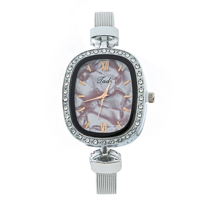 Detail of silver mesh band watch with rhinestone bezel and marble pattern dial