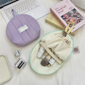 Flat lay view of a quilted makeup bag showing mint green interior pockets and main section