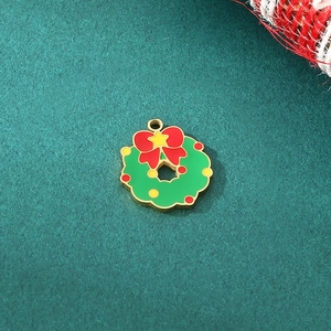 Detailed view of enamel Christmas wreath charm with red bow and yellow star on green base