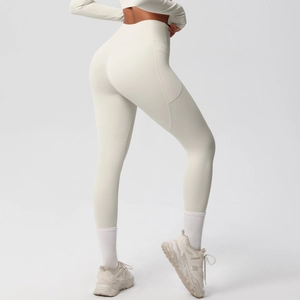 Detailed close-up of side pocket and high-elastic fabric on cream yoga leggings