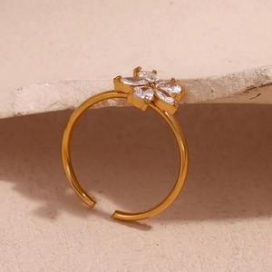 Macro shot of gold-plated flower ring with marquise-cut zircon petals on stone background