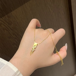 Gold plated wheat fringe tassel necklace with rectangle pendant and zircons in warm light