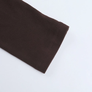 Gros plan détaillé du poignet en maille marron foncé avec couture précise à double aiguille