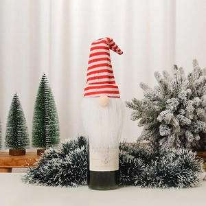 Détail du couvre-bouteille de Noël avec bonnet tricoté à rayures rouges et barbe blanche