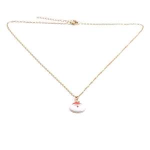 Gros plan détaillé d'un collier doré avec un pendentif Père Noël en émail blanc pur