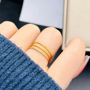 Detail showing a triple-layer matte gold stainless steel ring stacked on a finger
