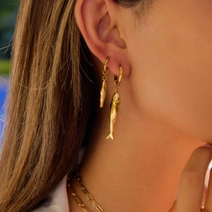 Modern 18k gold plated stainless steel hammered fish earrings worn by a model