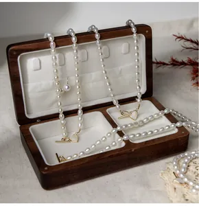 Detail of freshwater pearl necklace with golden heart OT buckle in walnut jewelry box