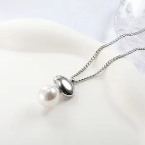 Detailed macro view of a large white pearl and polished silver oval pendant necklace