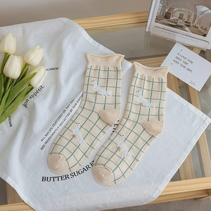 Detail of soft cotton crew socks with green plaid patterns and duck motifs