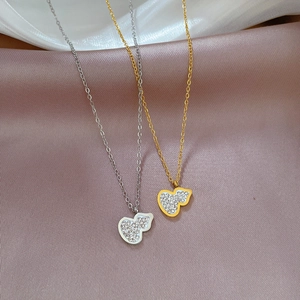 Detailed view of gold and silver gourd pendant necklaces with sparkling crystal pavé