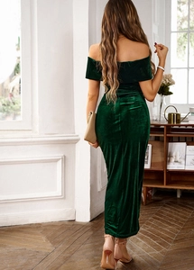 Elegant dark green velvet off-shoulder maxi dress showing a draped back cut and sleek silhouette