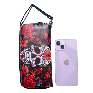 Long vintage zip wallet featuring skull and floral prints with wrist strap and smartphone