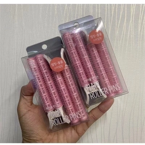 Pink hair roller pins for root volume and styling in portable transparent box