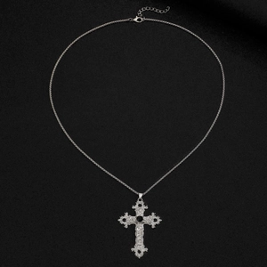 Gros plan du collier croix gothique en argent avec gravures baroques et pierres noires