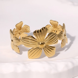 Polished gold stainless steel open cuff bracelet featuring five petal flower designs